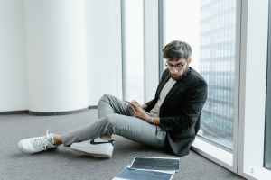 a man wearing black jacket looking at graphs on the floor